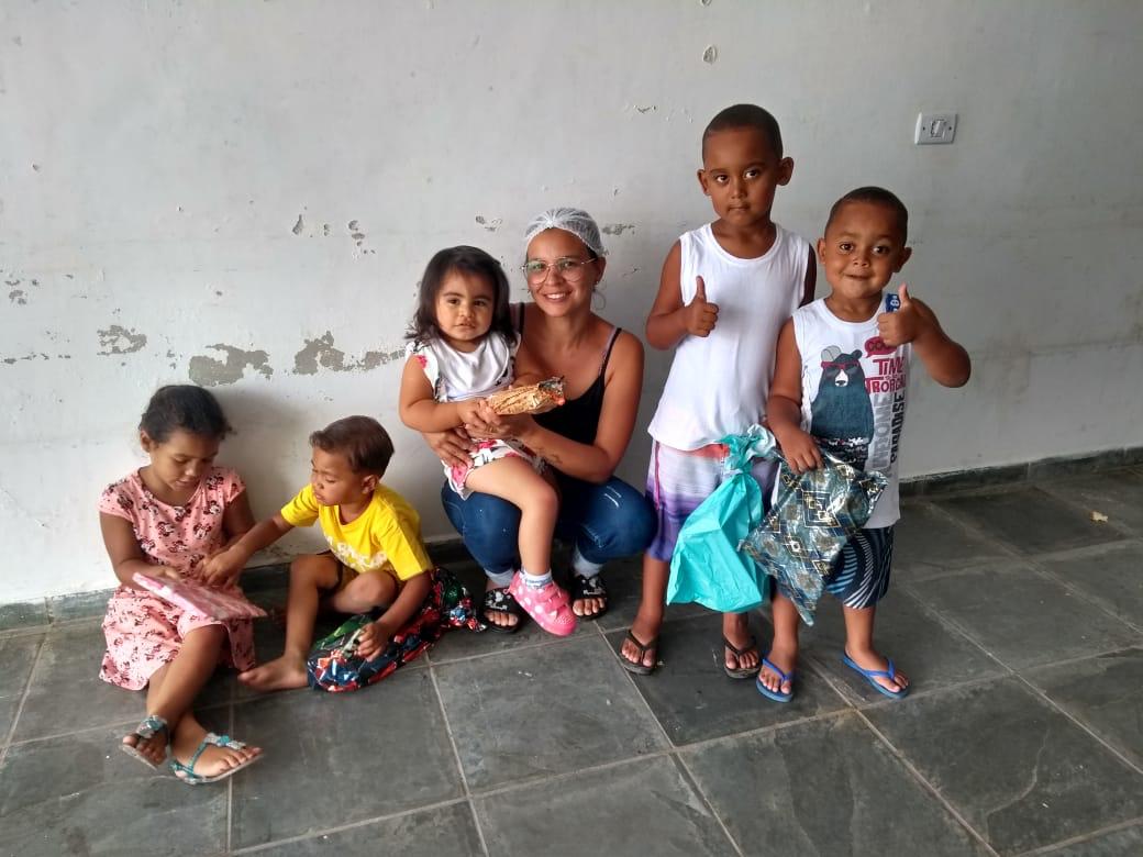 Voluntária e crianças após ação solidária
